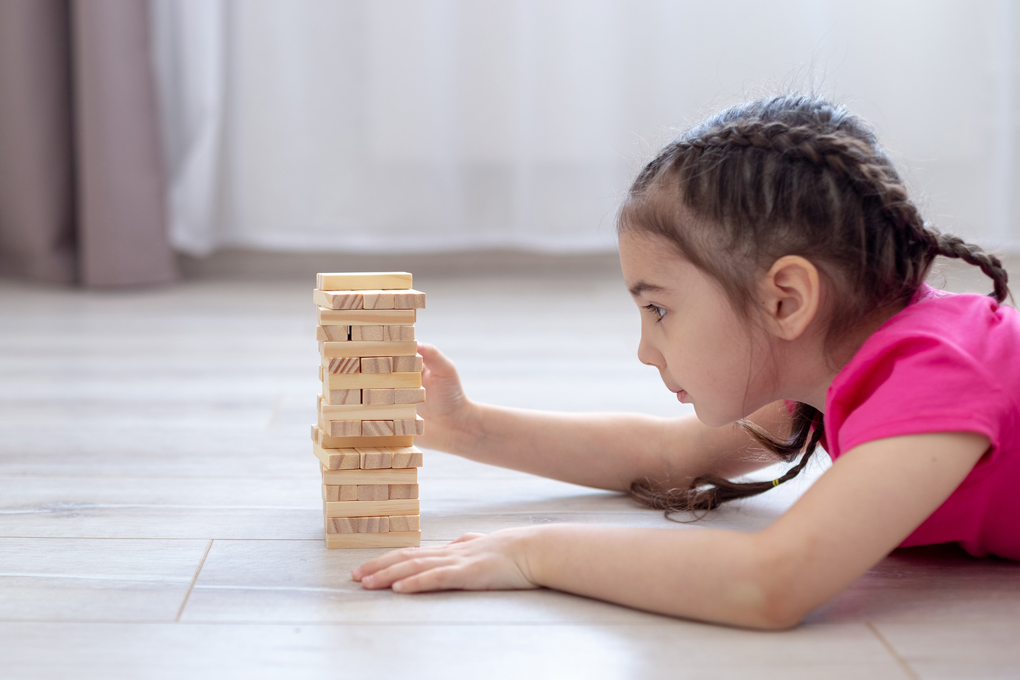 Kind spielt mit Holzblöcken auf Fussboden