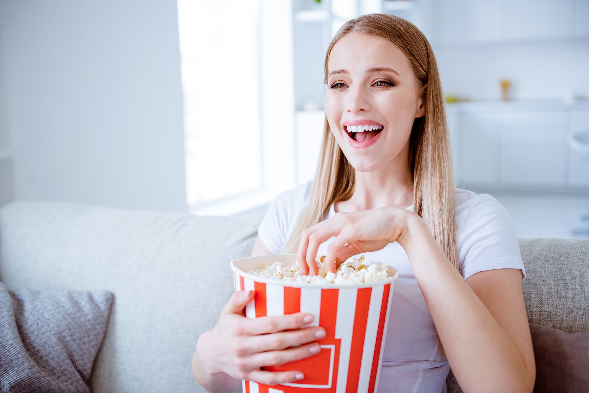 Frau schaut Film und isst Popcorn